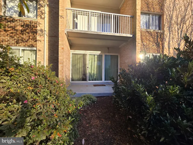 a view of a house with brick walls and flower plants