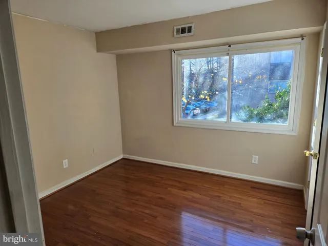 an empty room with wooden floor and a window