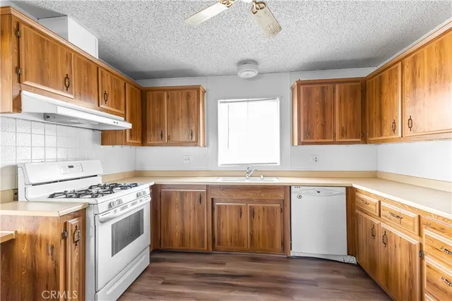 a kitchen with stainless steel appliances granite countertop a sink stove and cabinets