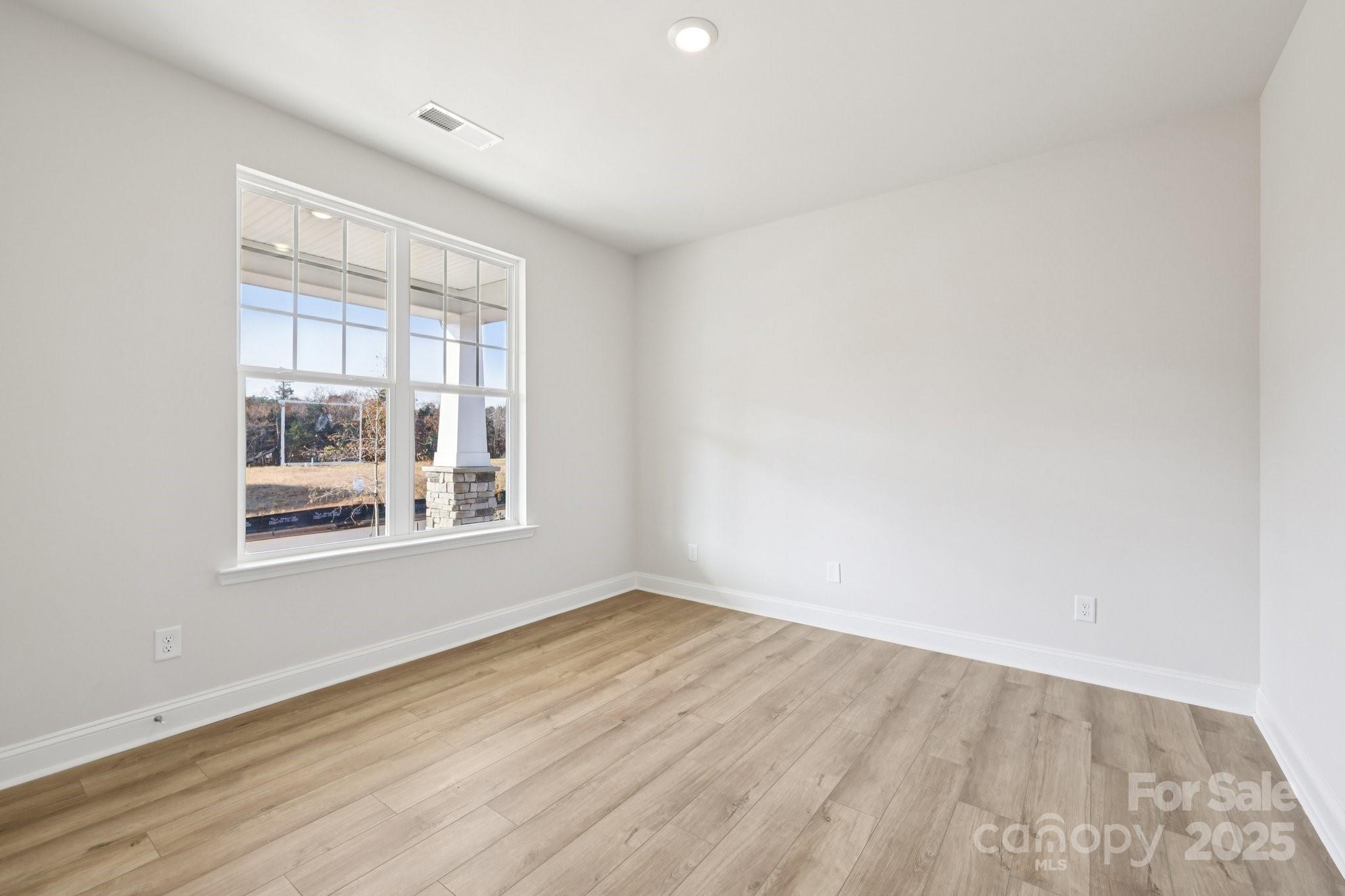 9612 Pointer Road, Unit 59 Huntersville, NC 28078 - Photo 20 of 43 a view of an empty room with wooden floor and a window