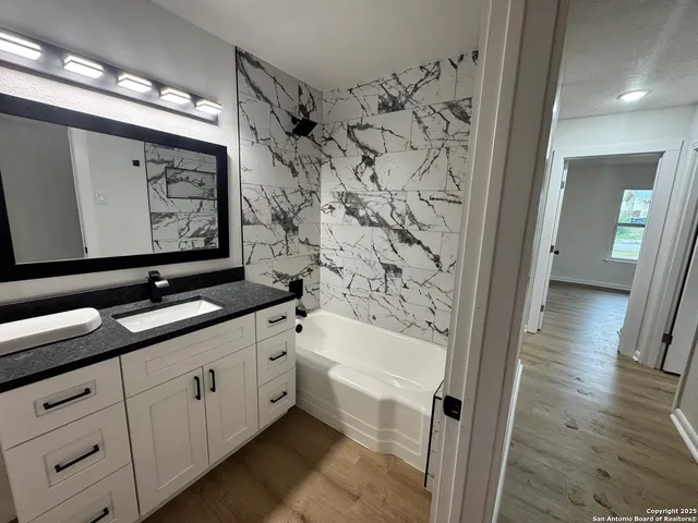 a bathroom with a double vanity sink a toilet a bathtub and shower