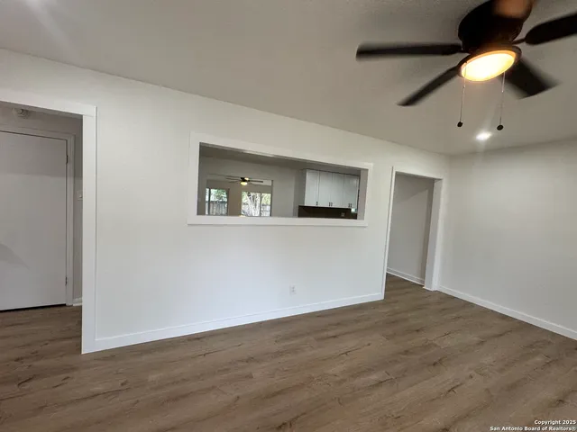 a view of an empty room with wooden floor