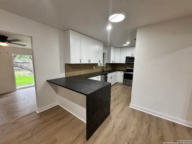 a view of kitchen with wooden floor and electronic appliances