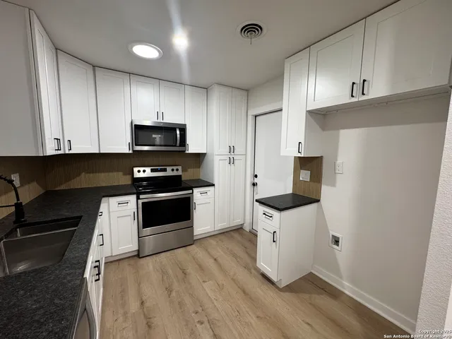a kitchen with a refrigerator and a stove top oven