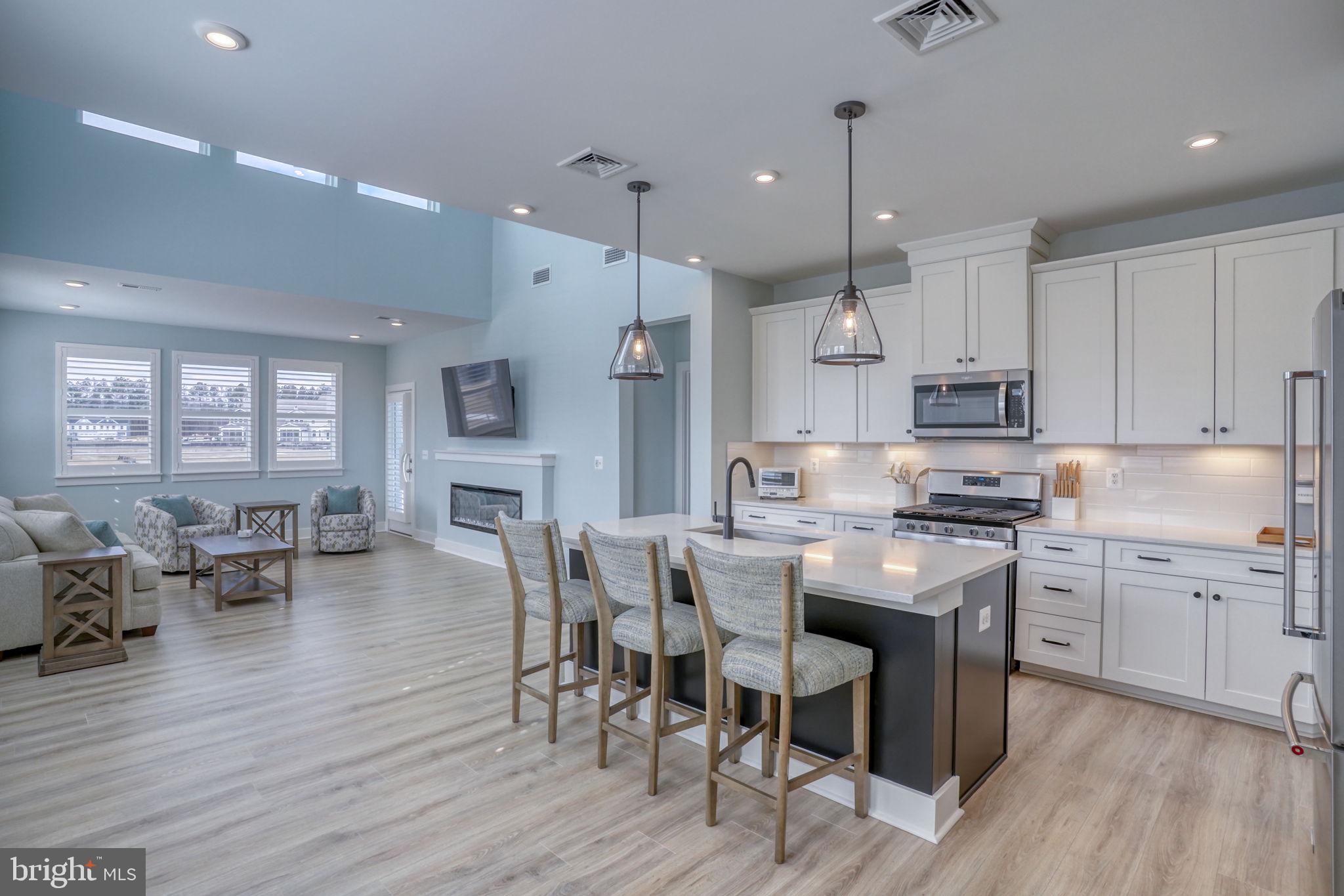 266 Exeter Street Ocean View, DE 19970 - Photo 59 of 62 a kitchen with stainless steel appliances granite countertop a stove a refrigerator a kitchen island a dining table and chairs with wooden floor