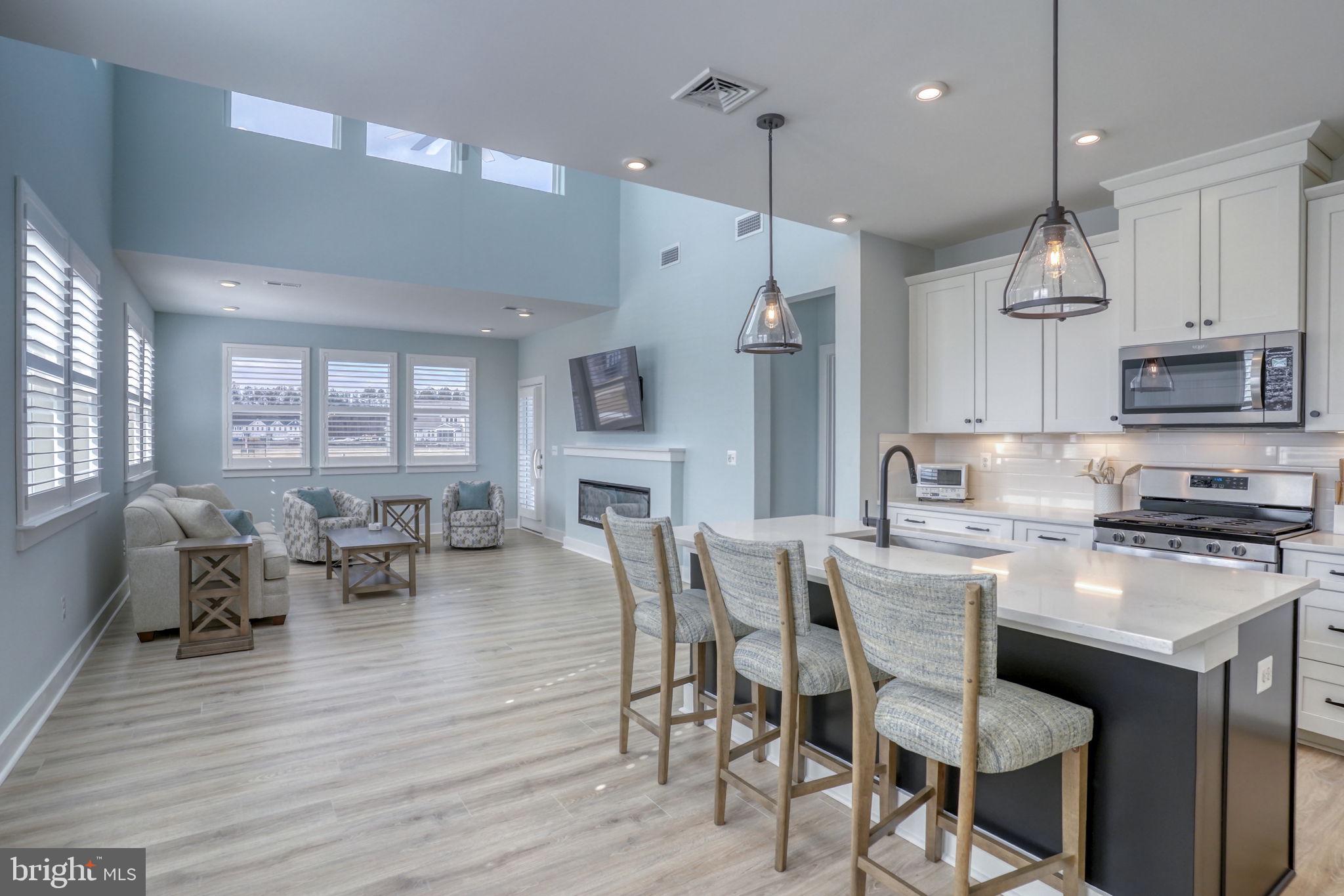 266 Exeter Street Ocean View, DE 19970 - Photo 6 of 62 a kitchen with stainless steel appliances granite countertop a stove a refrigerator a kitchen island a dining table and chairs with wooden floor