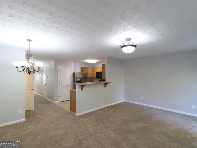 a view of a room with wooden floor and a chandelier