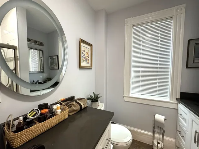 a bathroom with a sink a toilet and a mirror