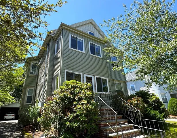 a front view of a house with plants