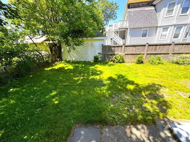 a backyard of a house with swimming pool and wooden fence