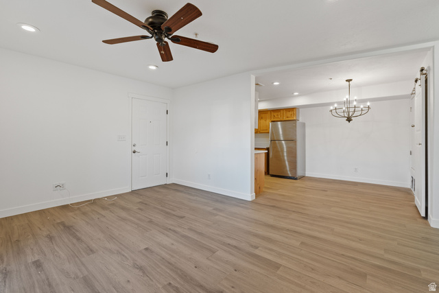 8204 North Cedar Springs Road, Unit 2 Eagle Mountain, UT 84005 - Photo 2 of 17 Unfurnished living room featuring a chandelier, ceiling fan, and light wood finished floors