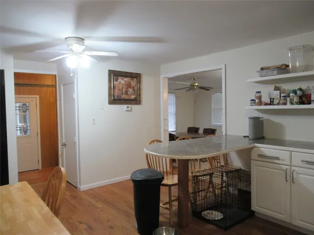 a room with a table chairs and chandelier