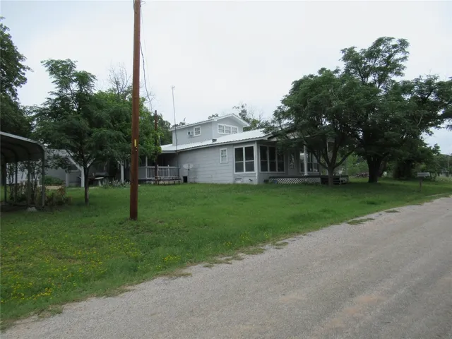 a front view of house with a garden and trees