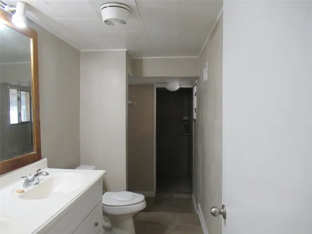 a bathroom with a sink toilet and a mirror