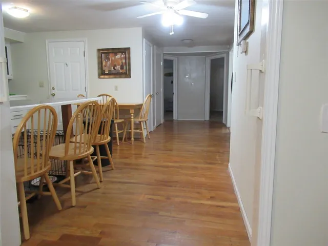a view of a hallway with wooden floor and chair