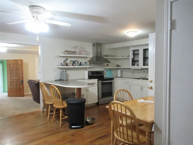 a kitchen with stainless steel appliances granite countertop a dining table chairs and granite counter tops