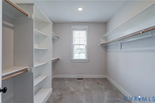 an aerial view of a residential houses with outdoor space and trees all around