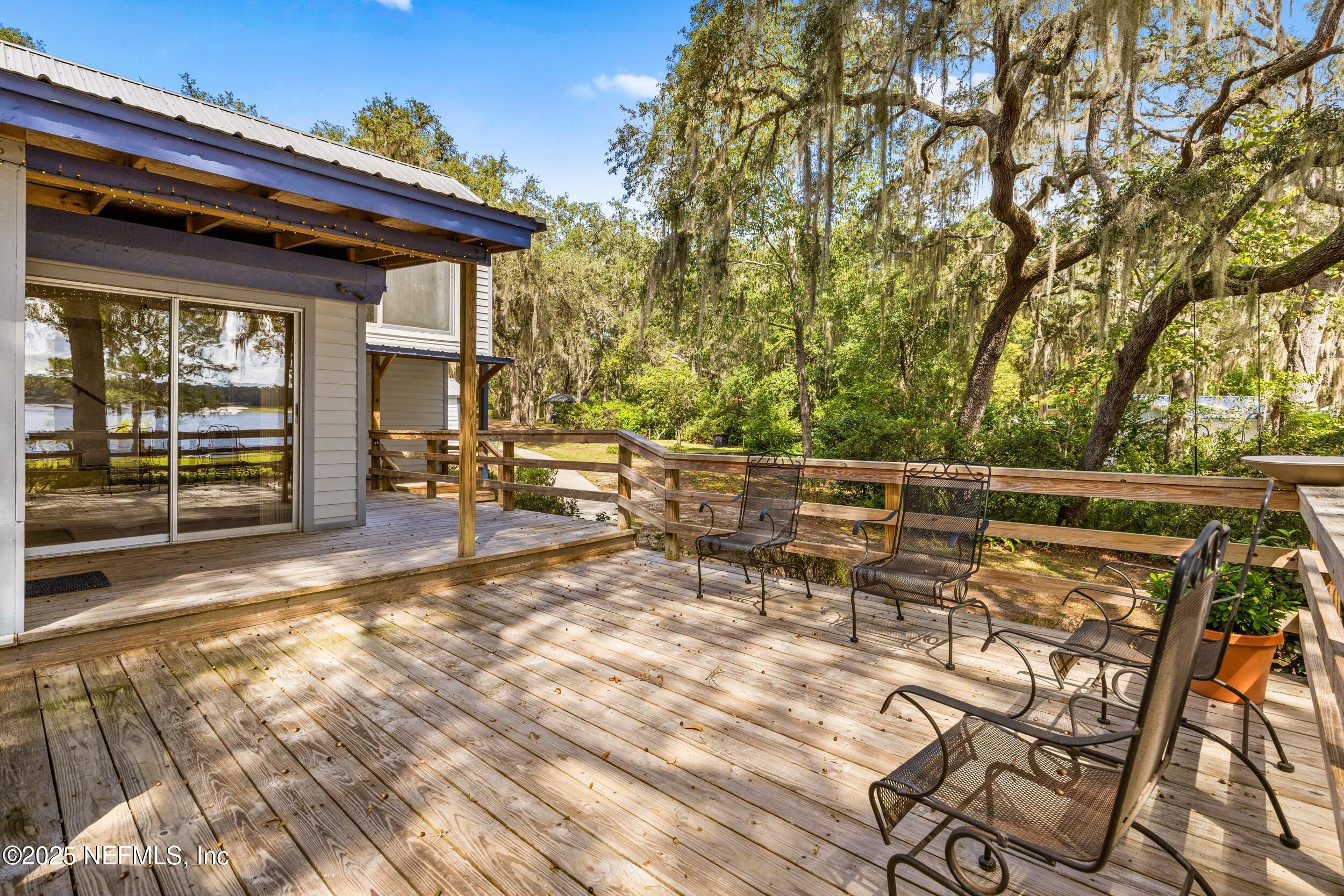 6441 Baker Road Keystone Heights, FL 32656 - Photo 40 of 66 a view of a patio with table and chairs with wooden floor and fence