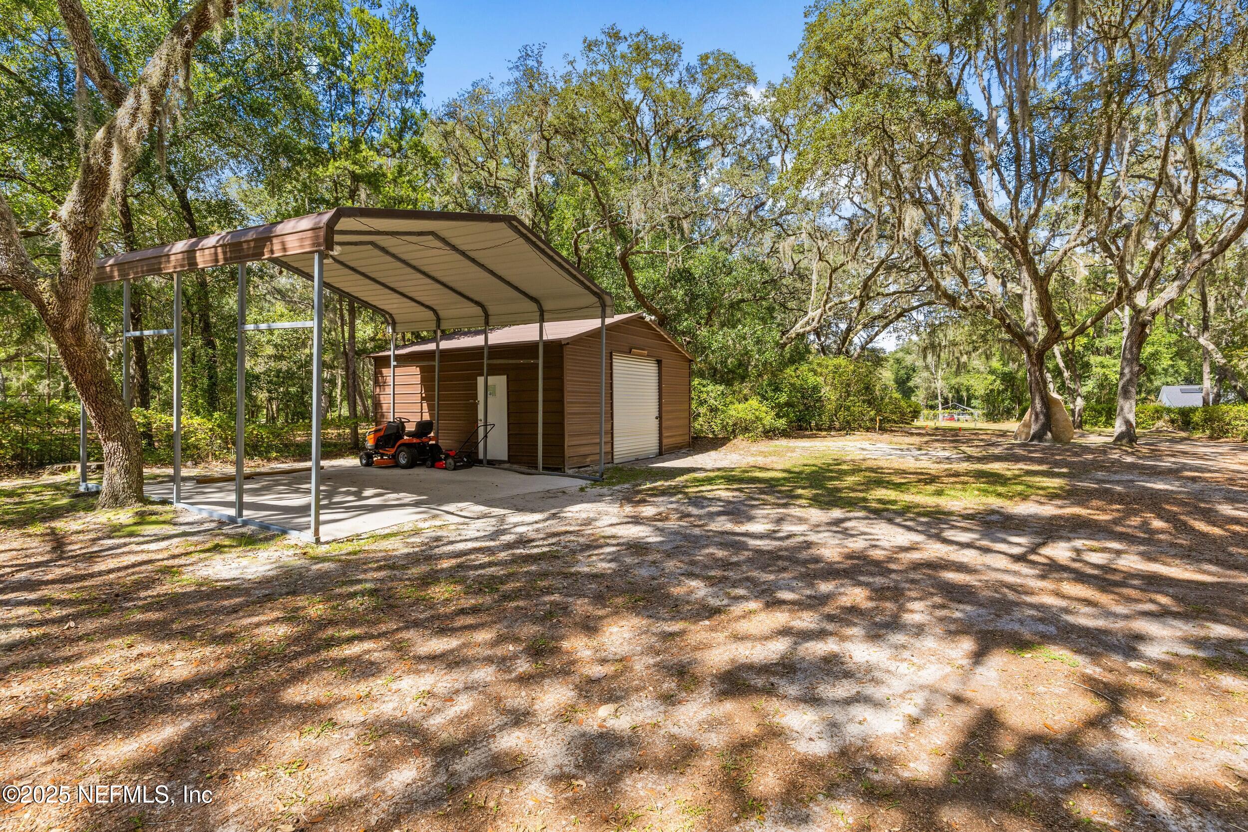 6441 Baker Road Keystone Heights, FL 32656 - Photo 50 of 66 a backyard of a house with large trees and outdoor seating
