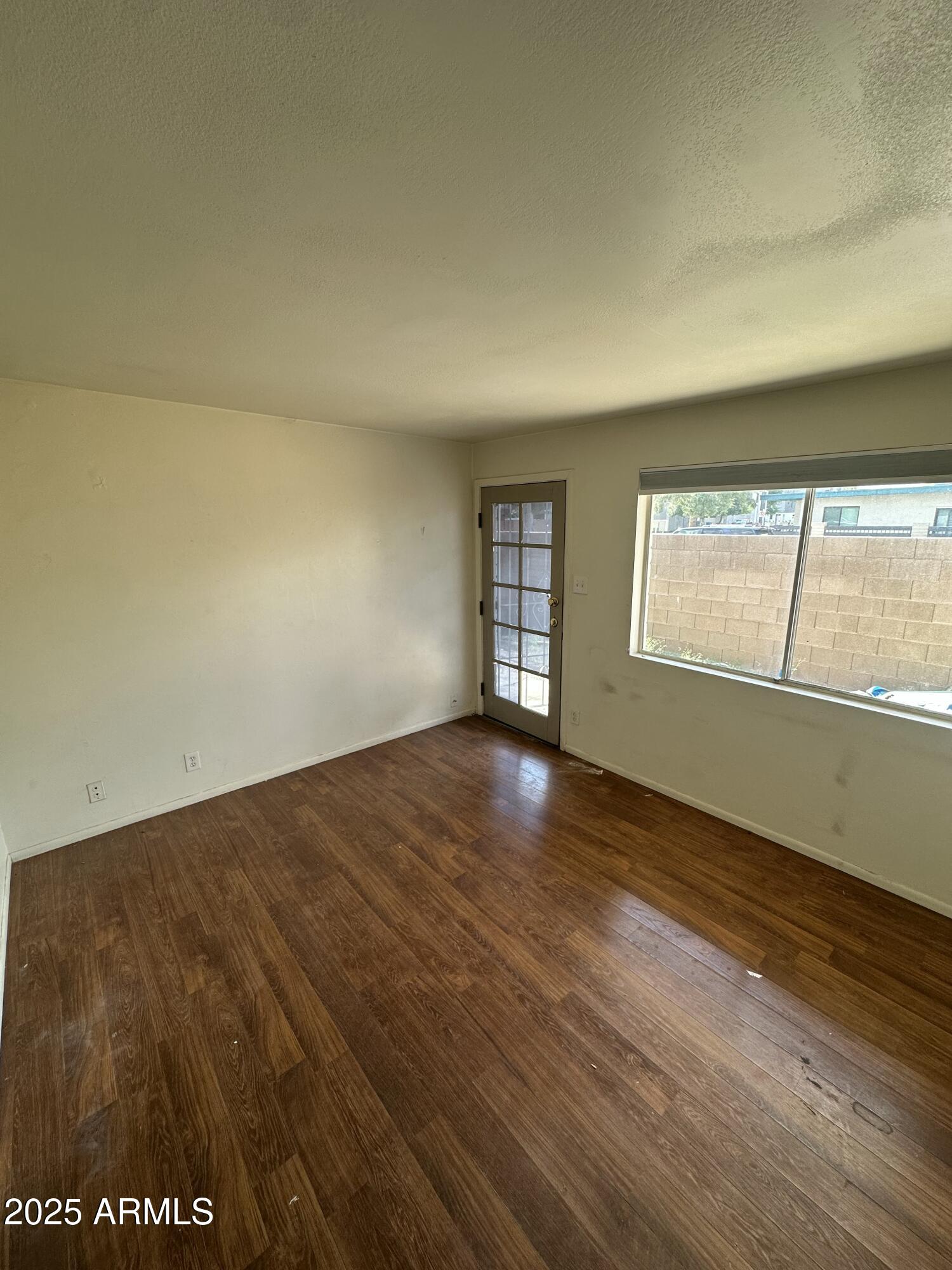 828 West 2nd Street, Unit C Tempe, AZ 85281 - Photo 4 of 15 an empty room with wooden floor and windows