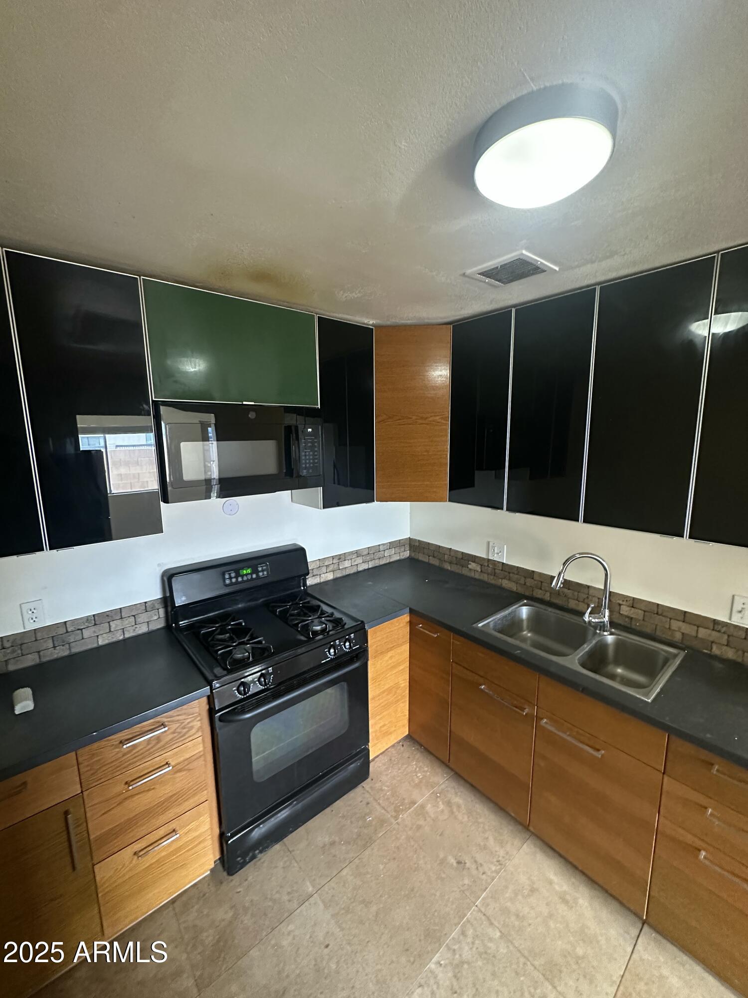828 West 2nd Street, Unit C Tempe, AZ 85281 - Photo 7 of 15 a kitchen with stainless steel appliances granite countertop a sink and a stove