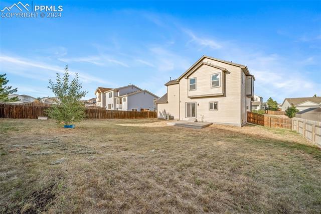 9356 Bethpage Road Peyton, CO 80831 - Photo 35 of 40 Rear view of house with a lawn and a patio area
