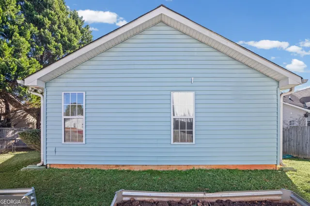 a view of backyard with swimming pool and seating area