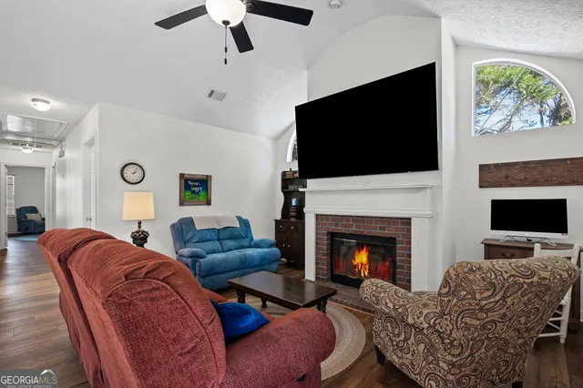a living room with furniture a flat screen tv and a fireplace