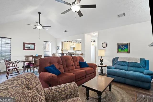 a living room with furniture a ceiling fan and a rug