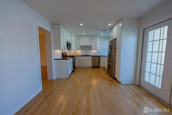 a kitchen with stainless steel appliances granite countertop a refrigerator and a stove top oven