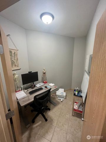 a view of a workspace with furniture and a window