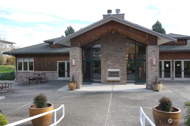 a front view of a house with outdoor seating and a lots of potted plants
