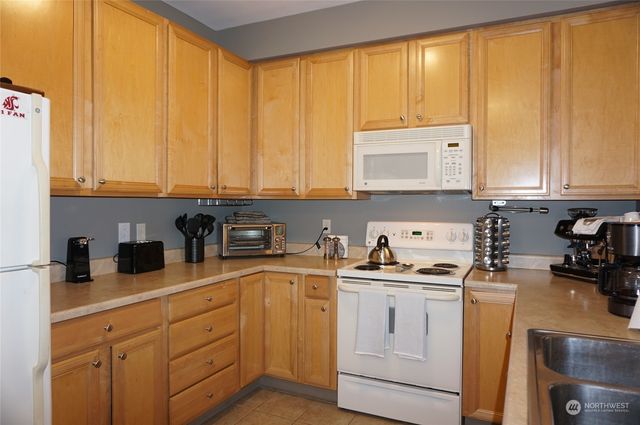 a kitchen with white cabinets and white appliances