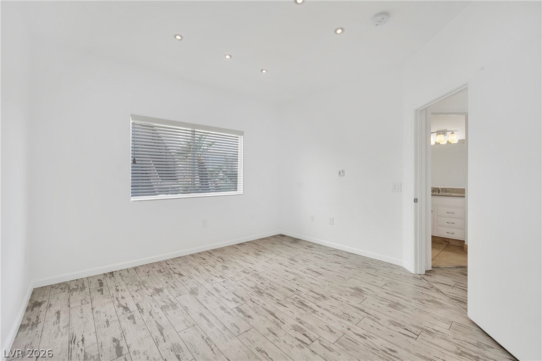 8725 West Flamingo Road, Unit 110 Las Vegas, NV 89147 - Photo 13 of 30 Recessed lighting illuminates this room with wood plank flooring and a private entrance to the bathroom.