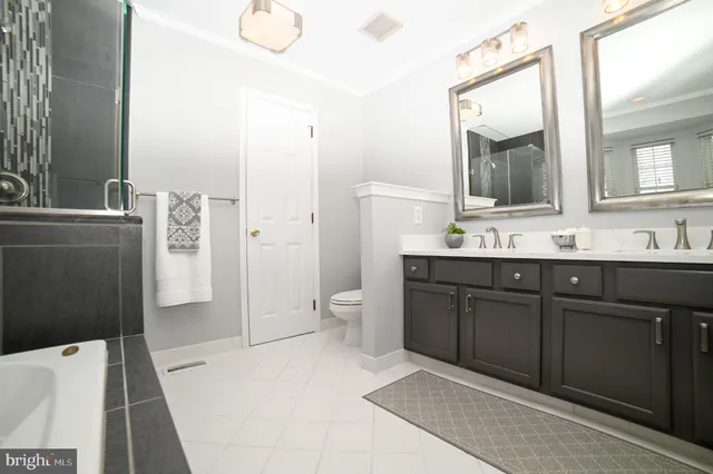 a spacious bathroom with a sink a toilet a shower and a mirror