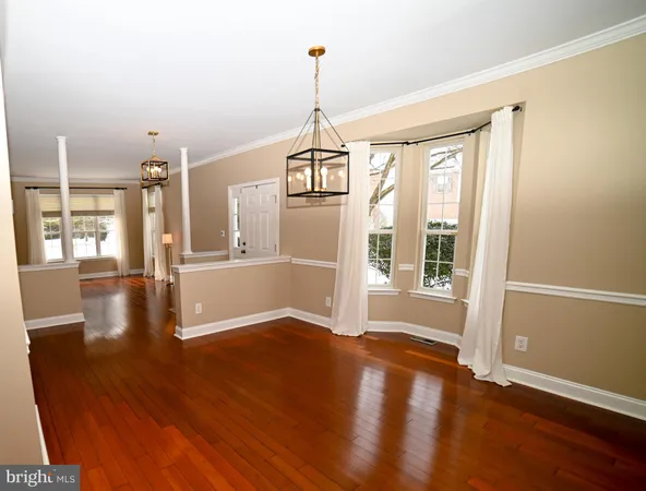 a view of a room with wooden floor fireplace and windows