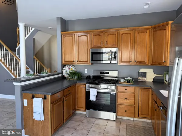 a kitchen with stainless steel appliances granite countertop a stove sink microwave and cabinets