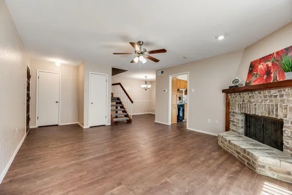 a view of an empty room with wooden floor a fireplace