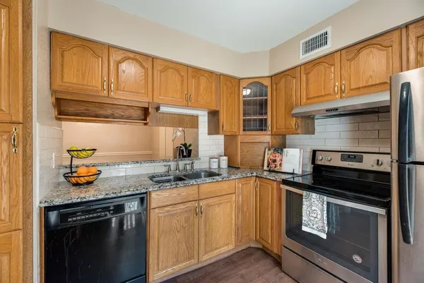 a kitchen with stainless steel appliances granite countertop a sink stove and cabinets