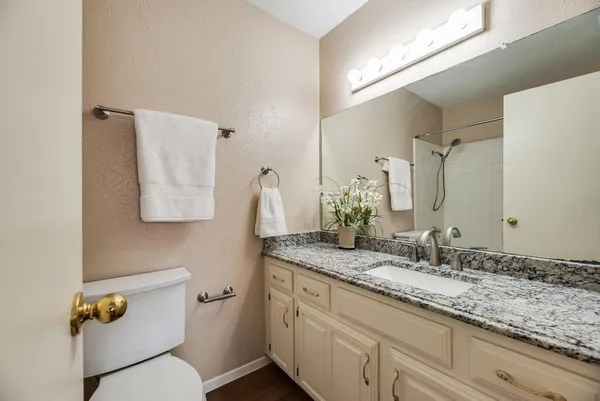 a bathroom with a granite countertop sink and a mirror