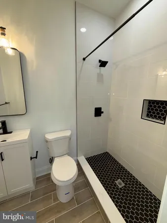 a bathroom with a sink a toilet a shower a toilet and a mirror