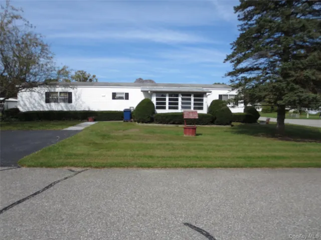 a front view of a house with a garden and trees