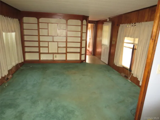 an empty room with windows and closet