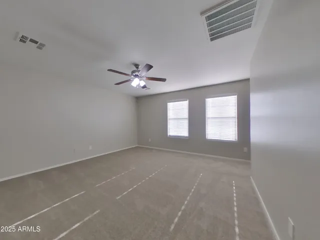 a view of an empty room with a chandelier fan