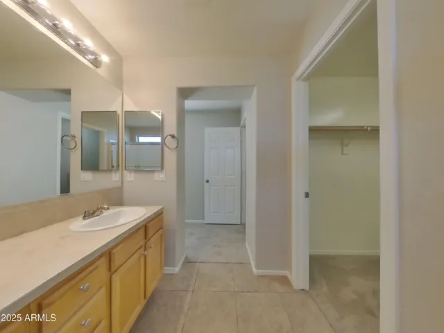 a view of an empty room with chandelier fan and fire place