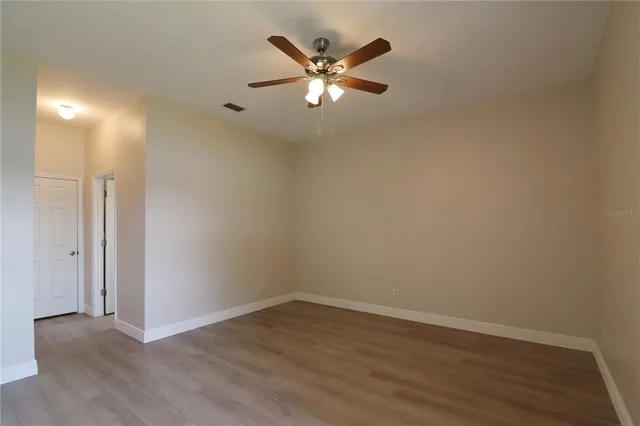 a view of an empty room with wooden floor