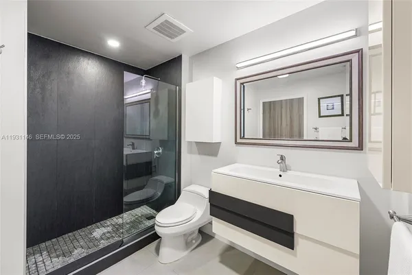a bathroom with a sink a toilet and shower