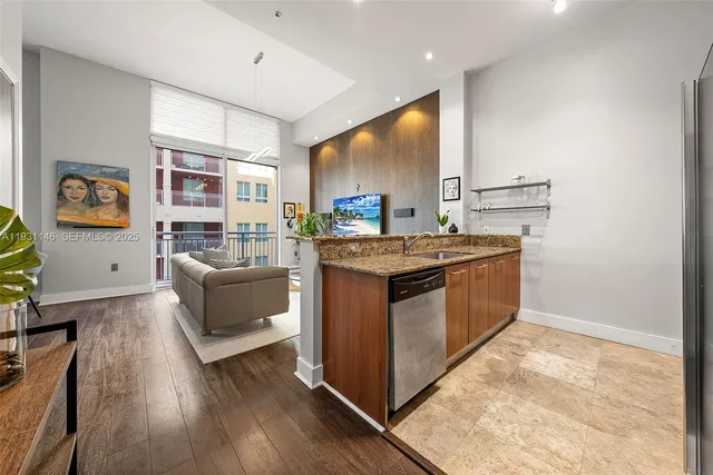 a utility room with stainless steel appliances granite countertop a stove and a refrigerator