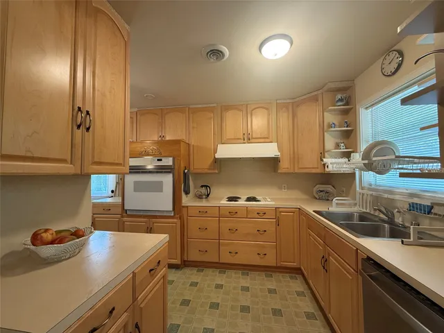 a kitchen with granite countertop a sink cabinets and stainless steel appliances