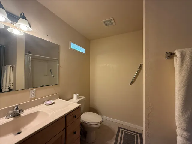a bathroom with a sink mirror vanity and toilet